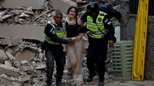 Policías y rescatistas asisten a una mujer herida tras el terremoto